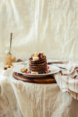 Chocolate pancakes with banana, peanut butter, green buckwheat and strawberries. Gluten-free fried sweet breakfast. Selective focus.Place for text