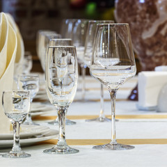 Empty glasses and white napkins are installed in the restaurant on the table