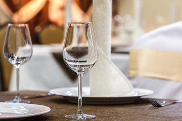 Empty glasses and white napkins are installed in the restaurant on the table