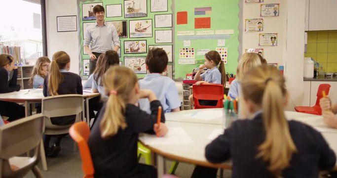4k, Elementary children and their teacher in a lesson at school. Slow motion.