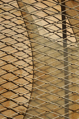 Old rusty metal lattice fence over a rusty metal background