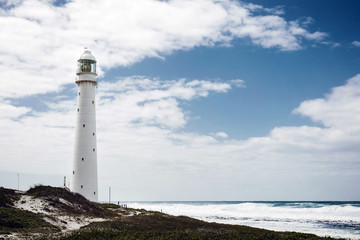 Fototapeta na wymiar Lighthouse on a rugged coastline with a vintage look in Cape Town