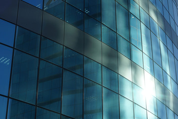 The glass facade of a skyscraper with a mirror reflection of sky windows. Photo.