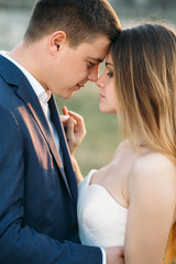 Wedding couple hugs tender standing on the green lawn