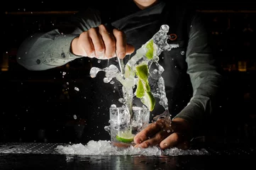 Papier Peint photo autocollant Cocktail Main de barman pressant du jus frais de citron vert faisant un cocktail Caipirinha