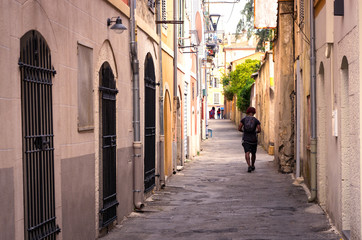 Backside view of a man walking along a mediterranean alley in Vallauris, Cote d'Azur