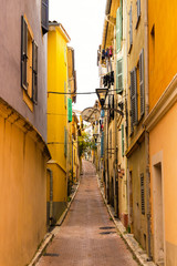 Fototapeta na wymiar Scene of an empty yellow mediterranean alley in Vallauris, Cote d'Azur