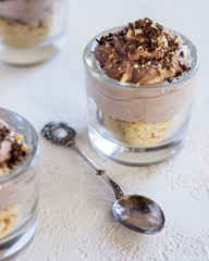 A mouth-watering dessert in the form of ice cream with cookies and chocolate mousse. In glass cups. Selective focus. Close up.