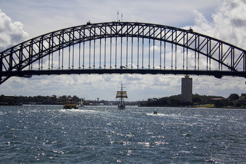 Old Tall Ship sailing through iconic Sydney harbour bridge 