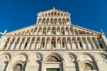 Fototapeta na wymiar Facade of the cathedral (Duomo) in Pisa on blue background, Tuscany, Italy