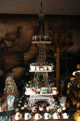 Delicious cakes with colorful cream stand on the Eiffel tower on candy bar