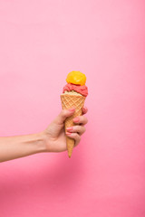  A woman's hand holding a three-ball ice cream