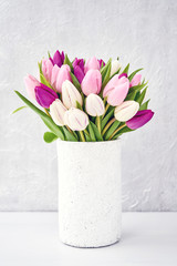 Pink and white tulips bouquet in old white vase. Holiday concept
