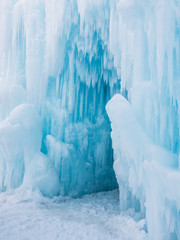 Winter ice castle caves with frozen icicles at sunset.