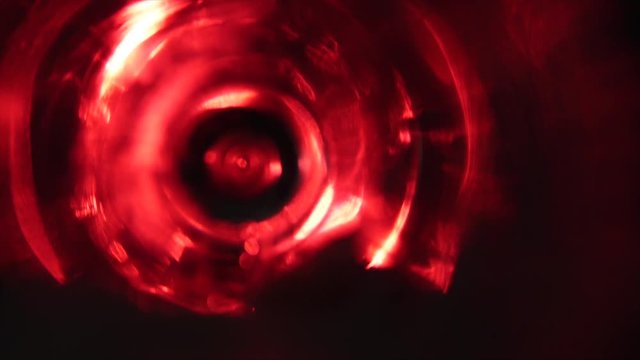 a glass with foam on a black background. Floodlight with a pink filter in the back. close up