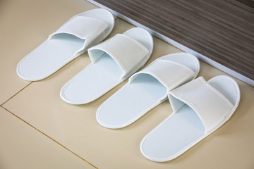A pair of white slippers on a hotel floor