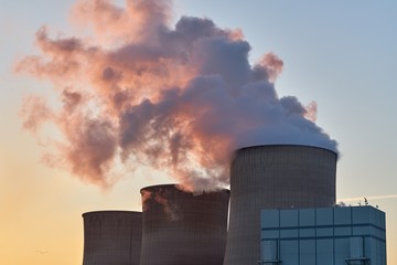 Kohlekraftwerk, Dampfender Kühlturm im Gegenlicht bei Sonnenuntergang



