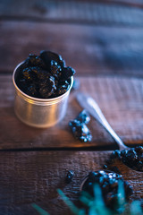Still life of grapes and prunes on a wooden background.