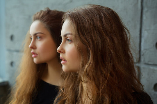 portrait of two beautiful young girls of twin sisters with flowing hair