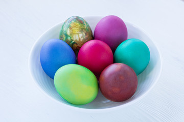 Fototapeta na wymiar White plate of Easter multicolored boiled eggs decoration isolated