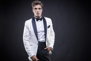 Businessman standing Stylish Luxury, elegant man in a white suit tuxedo with bow tie around his neck