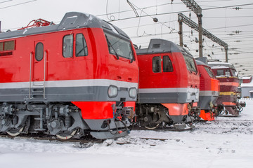 Obraz premium Electric locomotives are lined up on the railway in winter snow depot.