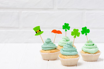 St. Patrick's Day theme colorful horizontal banner. Cupcakes decorated with green buttercream and...