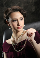 beautiful brunette girl with beads in retro style