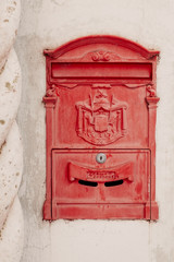 Vintage post box on white wall.