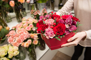 Female hands hold red box with flowers