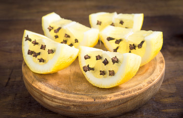 slices of lemon with clove spice, on rustic wood
