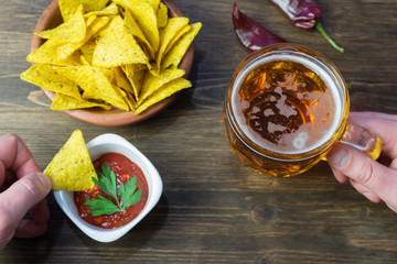 Nachos corn chips with classic tomato salsa. Fresh cold beer is perfect with savory snacks.