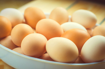 white and brown fresh chicken eggs in a plate. concept of easter. cooking ingredients