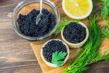 Black caviar on a sandwich. Put a silver spoon on the sandwich.