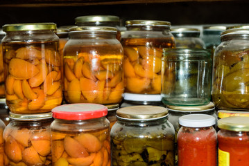 Fototapeta na wymiar Preservation of berries and vegetables. Canned apricot, green pepper, tomatos In the basement, conservation for the winter. Bulgaria