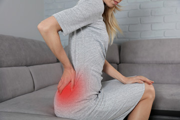 Woman suffering from low back pain. Incorrect sitting posture problems, Muscle spasm, rheumatism....