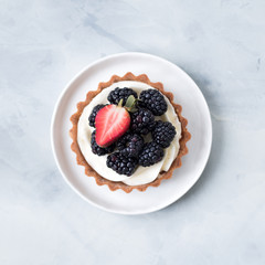 Berries creamy tarts served on white plate