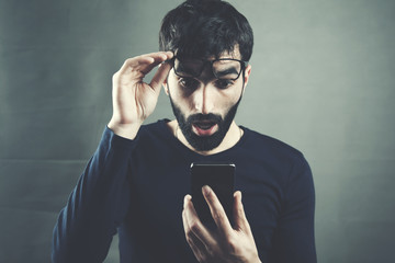 Portrait of surprised man  looking at smartphone