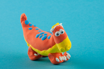 Diplodocus. Play dough modelling, orange figure on blue background