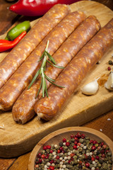 Raw sausages on wooden background
