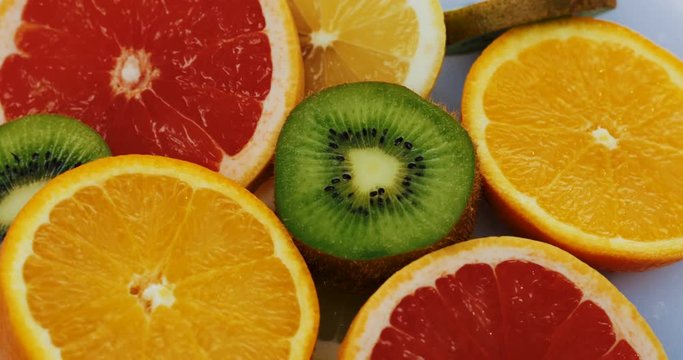 Top view on the halves fruits spinning on the white background. Macro shooting. Close up