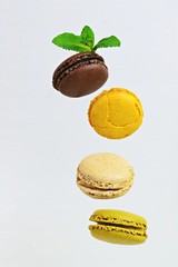 Different types of macaroons in motion falling on a white background. Macarons levitation. Macaroons isolated