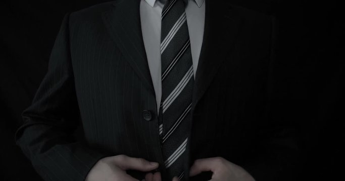 Businessman in suit, black background.