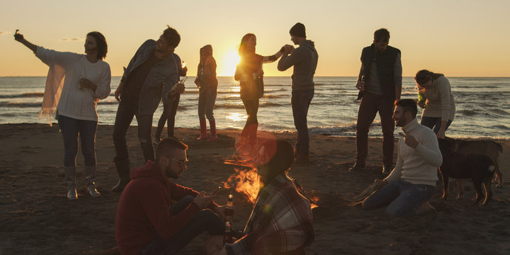 Friends having fun at beach on autumn day