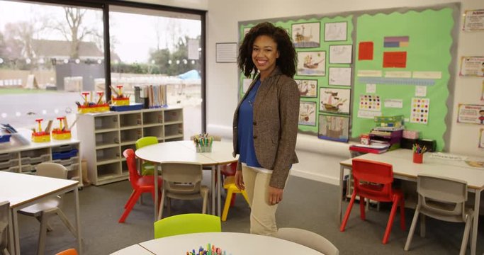 4k, Portrait of a smiling female African American teacher in classroom. Slow motion