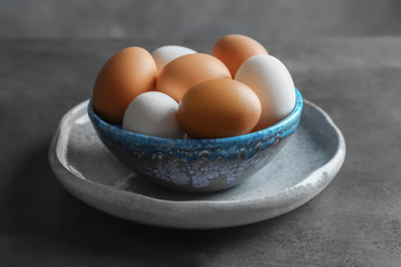 Plate with chicken eggs on table