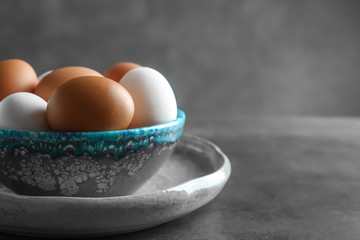 Plate with chicken eggs on table