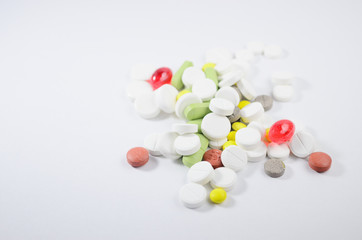 White surface with colorful pills and capsules. Mock up