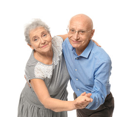 Cute elderly couple dancing against white background