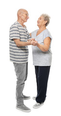 Cute elderly couple dancing against white background